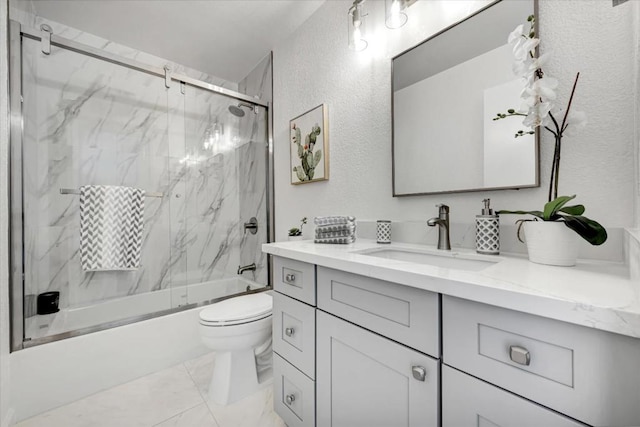 full bathroom featuring toilet, vanity, and shower / bath combination with glass door