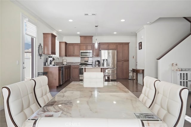 dining room with sink, hardwood / wood-style flooring, and ornamental molding