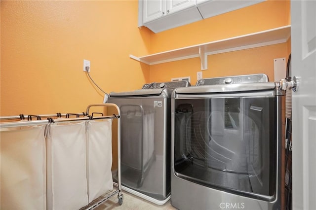 washroom featuring cabinets and washing machine and dryer