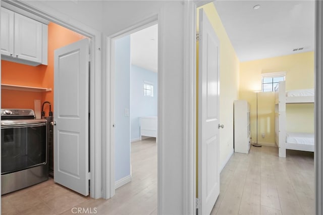 corridor featuring washer / clothes dryer and light hardwood / wood-style flooring