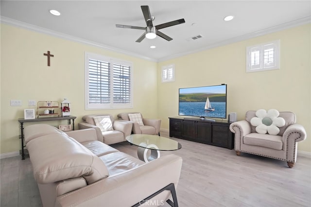 living room featuring light hardwood / wood-style flooring, ornamental molding, and a healthy amount of sunlight