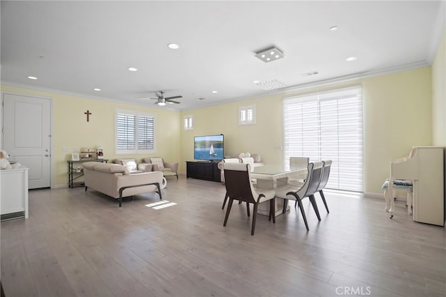 dining room with crown molding, ceiling fan, and light wood-type flooring