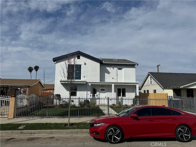 view of front facade with a fenced front yard and stucco siding