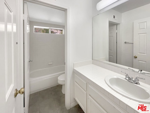 full bathroom with vanity, tiled shower / bath, tile patterned floors, and toilet