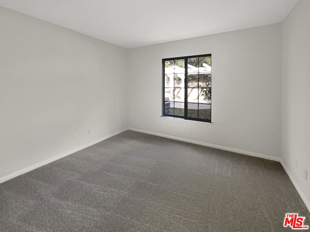 unfurnished room featuring dark carpet