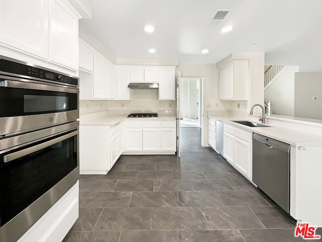 kitchen featuring stainless steel appliances, white cabinetry, sink, and kitchen peninsula