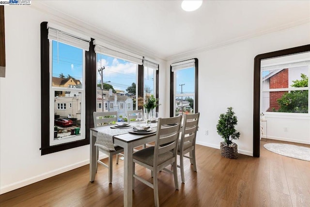 dining area with ornamental molding, dark wood-type flooring, and a wealth of natural light