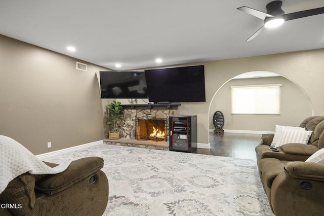 living room with ceiling fan, a fireplace, and hardwood / wood-style floors