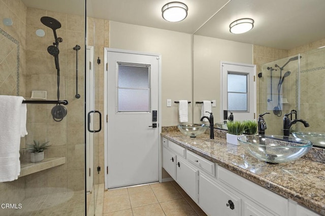 bathroom featuring tile patterned floors, a shower with door, and vanity