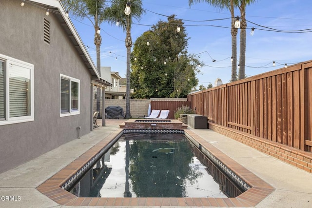 view of pool featuring a jacuzzi and a patio area