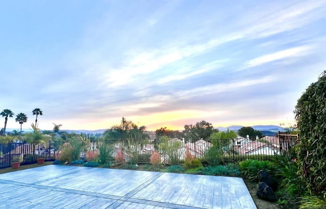 pool at dusk featuring fence