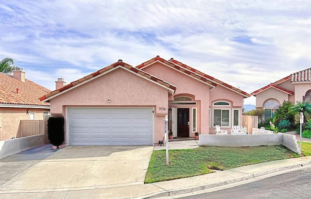 view of front of home with a garage, concrete driveway, fence, and stucco siding