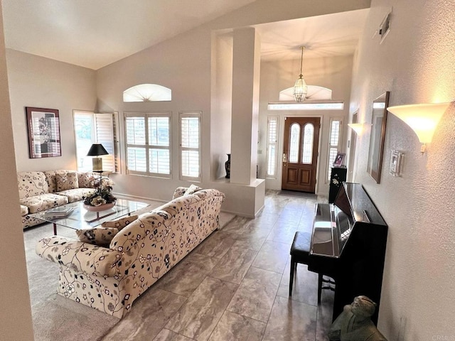 living room with baseboards and high vaulted ceiling