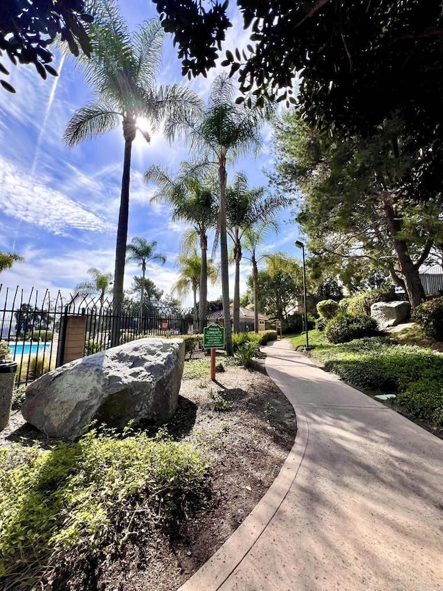 view of community with a swimming pool and fence