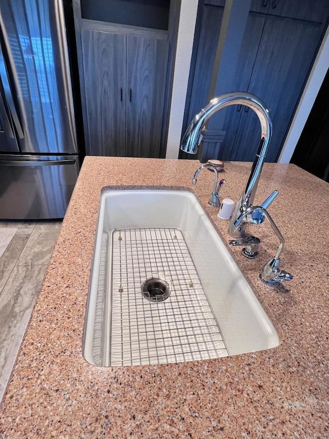 interior details with freestanding refrigerator and a sink