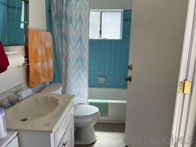 full bathroom featuring shower / tub combo with curtain, vanity, and toilet