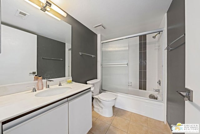 full bathroom with tile patterned flooring, enclosed tub / shower combo, vanity, and toilet