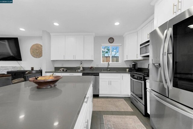 kitchen with stainless steel appliances, sink, and white cabinets