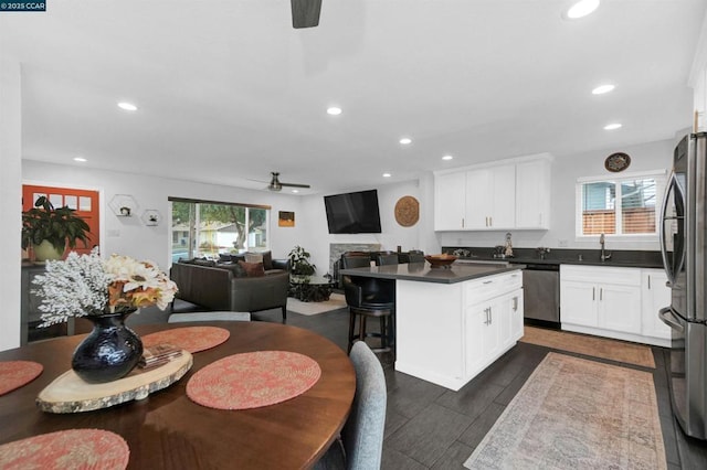 kitchen with white cabinetry, plenty of natural light, stainless steel appliances, and a kitchen island