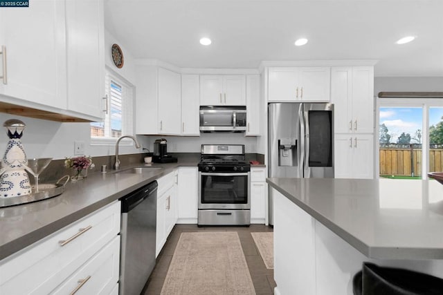 kitchen featuring appliances with stainless steel finishes, sink, and white cabinets