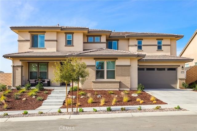 39767 Larkspur Ter, Temecula, CA 92591 - prairie-style house with covered porch, an attached garage, brick siding, driveway, and stucco siding