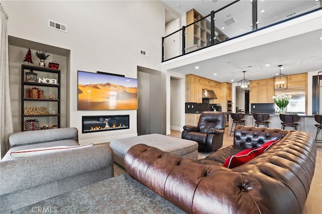 living room with a towering ceiling and an inviting chandelier