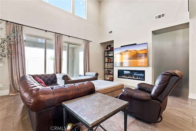 39767 Larkspur Ter, Temecula, CA 92591 - living area with marble tiled flooring, a towering ceiling, and a glass covered fireplace