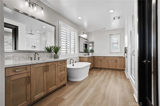 39767 Larkspur Ter, Temecula, CA 92591 - full bathroom featuring a shower stall, two vanities, wood finished floors, a freestanding tub, and recessed lighting