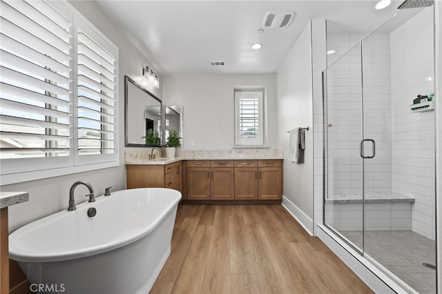 39767 Larkspur Ter, Temecula, CA 92591 - full bathroom featuring wood finished floors, a shower stall, a freestanding bath, double vanity, and recessed lighting