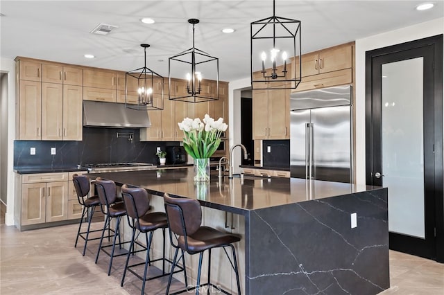 39767 Larkspur Ter, Temecula, CA 92591 - kitchen with stainless steel appliances, under cabinet range hood, light brown cabinets, recessed lighting, and decorative backsplash