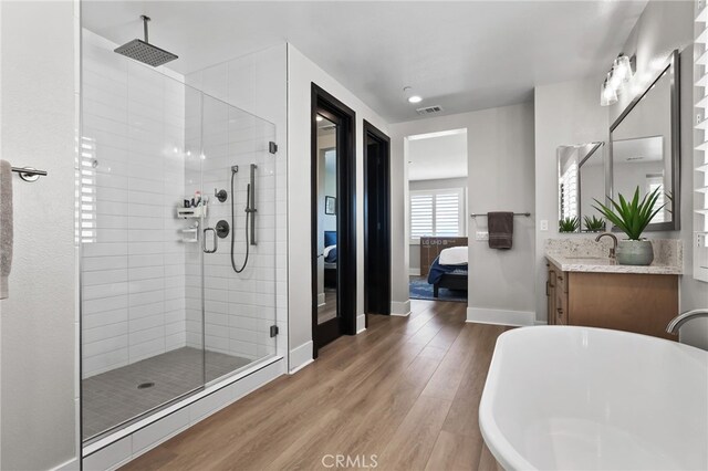 39767 Larkspur Ter, Temecula, CA 92591 - full bath featuring connected bathroom, a shower stall, a freestanding tub, wood finished floors, and vanity