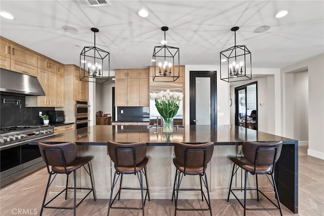39767 Larkspur Ter, Temecula, CA 92591 - kitchen featuring dark countertops, light brown cabinetry, under cabinet range hood, appliances with stainless steel finishes, and decorative backsplash