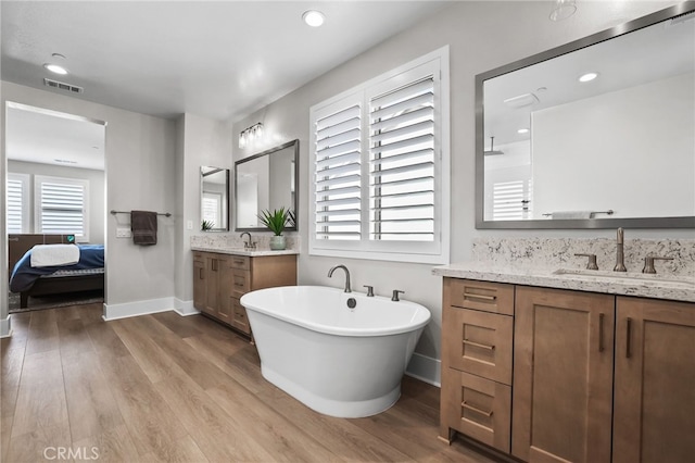 39767 Larkspur Ter, Temecula, CA 92591 - bathroom featuring two vanities, wood finished floors, a soaking tub, and recessed lighting