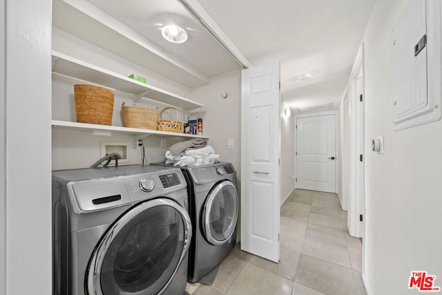 laundry room featuring light tile patterned floors, electric panel, and washing machine and clothes dryer