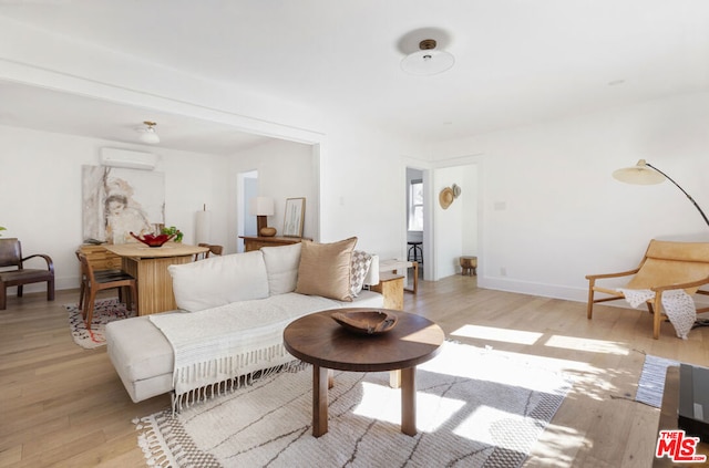 living room featuring a wall mounted AC and light wood-type flooring