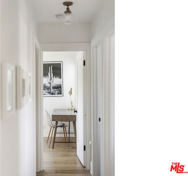 corridor with light hardwood / wood-style floors