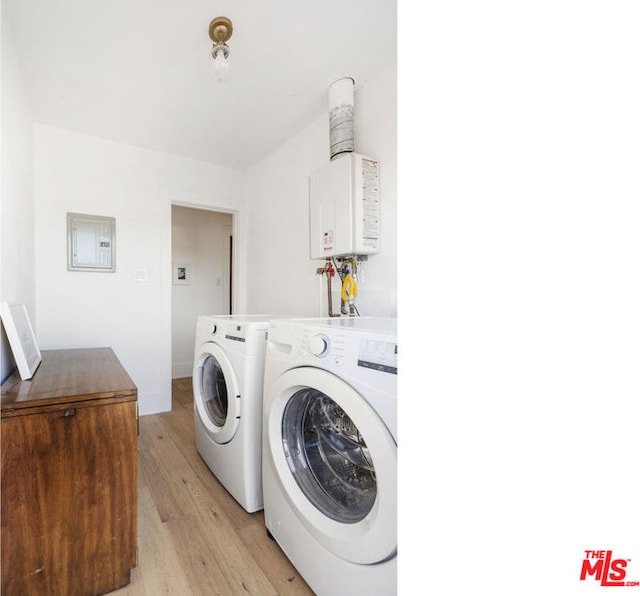 clothes washing area featuring water heater, light wood-type flooring, electric panel, and independent washer and dryer