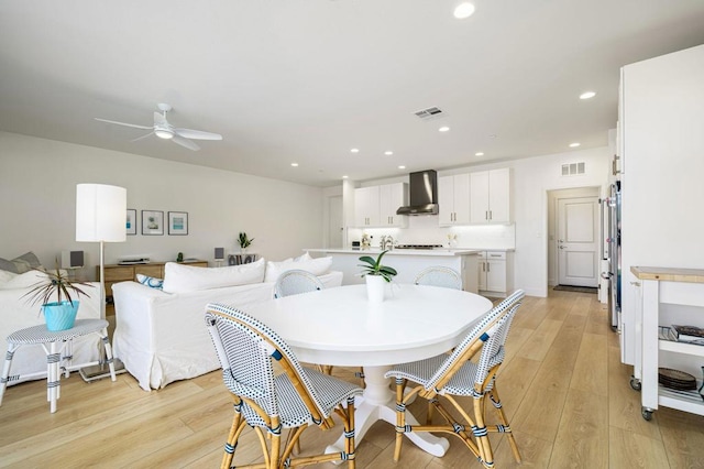 dining space with light hardwood / wood-style flooring and ceiling fan