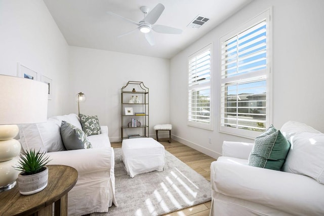 living room featuring ceiling fan and light hardwood / wood-style floors