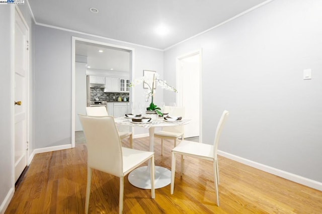 dining room featuring ornamental molding and hardwood / wood-style floors