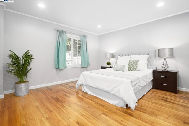 bedroom featuring ornamental molding and light hardwood / wood-style flooring