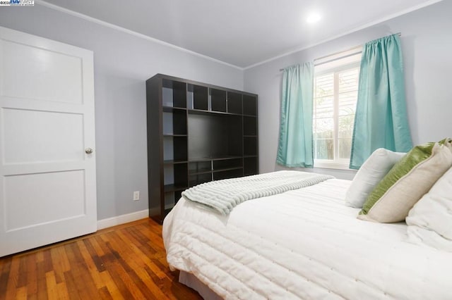 bedroom with crown molding and hardwood / wood-style flooring