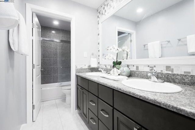 full bathroom featuring tiled shower / bath, vanity, toilet, and tile patterned floors