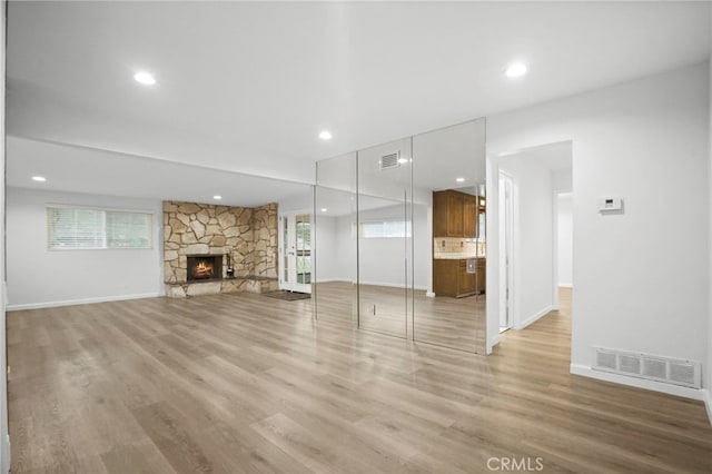 unfurnished living room with a fireplace and light hardwood / wood-style floors