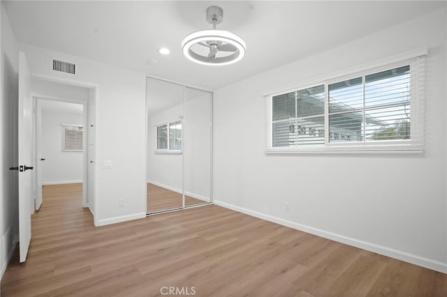 unfurnished bedroom featuring light hardwood / wood-style floors and a closet