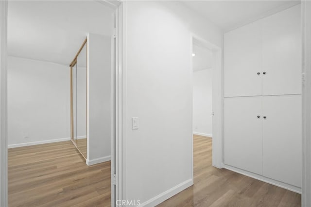 hallway with light hardwood / wood-style floors