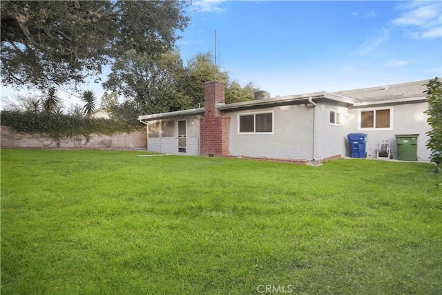 rear view of property with a yard