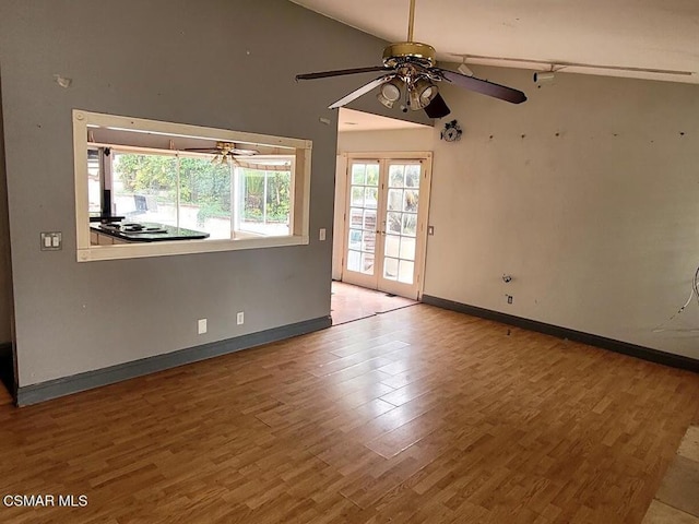 spare room featuring hardwood / wood-style flooring, ceiling fan, vaulted ceiling, and french doors