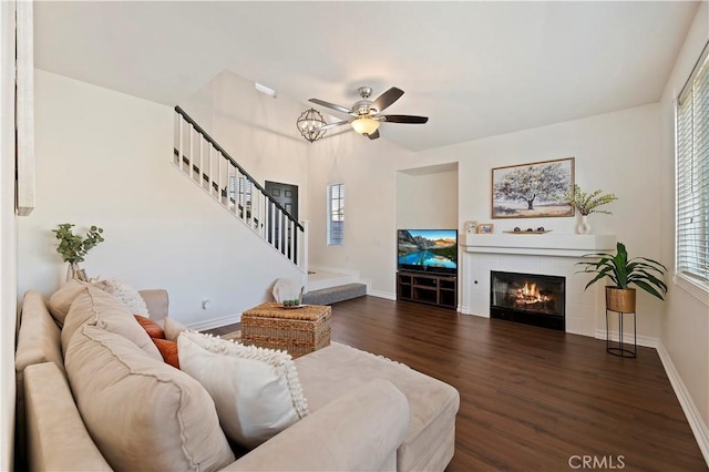 living room featuring ceiling fan, a tile fireplace, dark hardwood / wood-style floors, and a healthy amount of sunlight