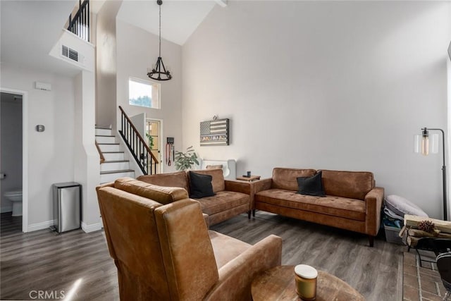 living room with dark hardwood / wood-style flooring and high vaulted ceiling